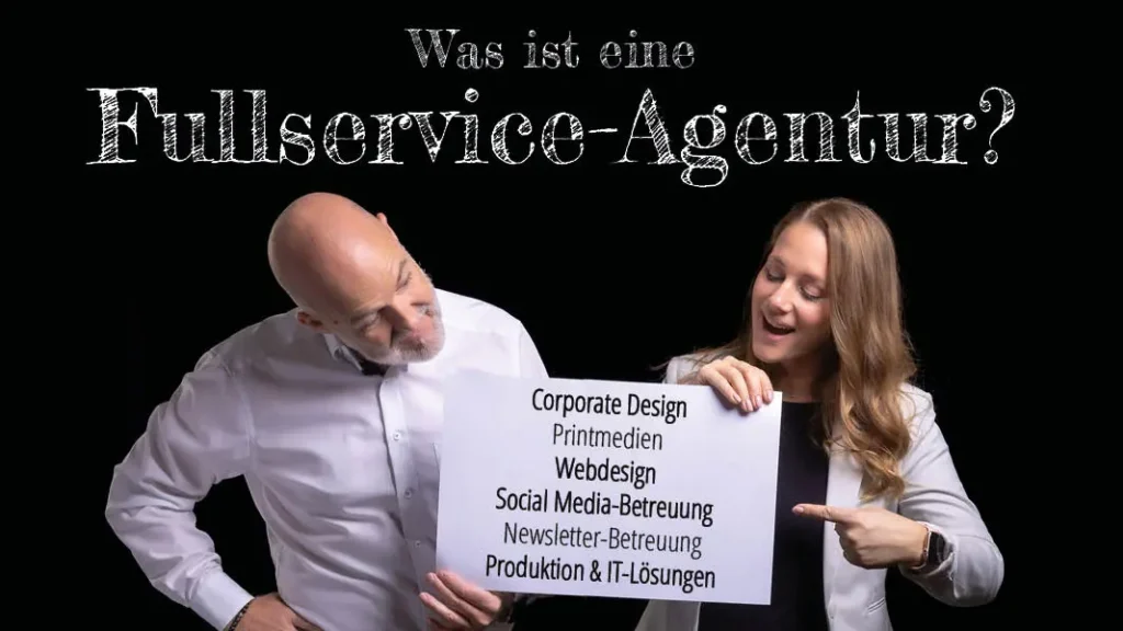Oben steht der Text: "Was ist eine Fullservice-Agentur?" Darunter halten Johannes und Sabrina ein Schild mit den Leistungen von EINSigartig - kreative Werbeagentur im Weinviertel