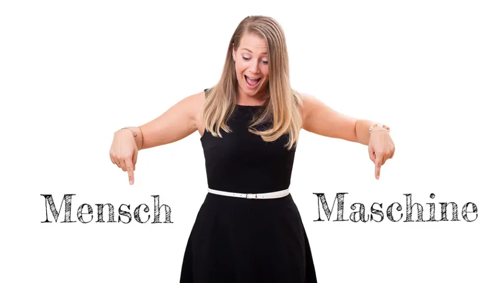 Sabrina zeigt mit ihren Händen auf die zwei Texte: "Mensch", "Maschine" - Seitenladegeschwindigkeit